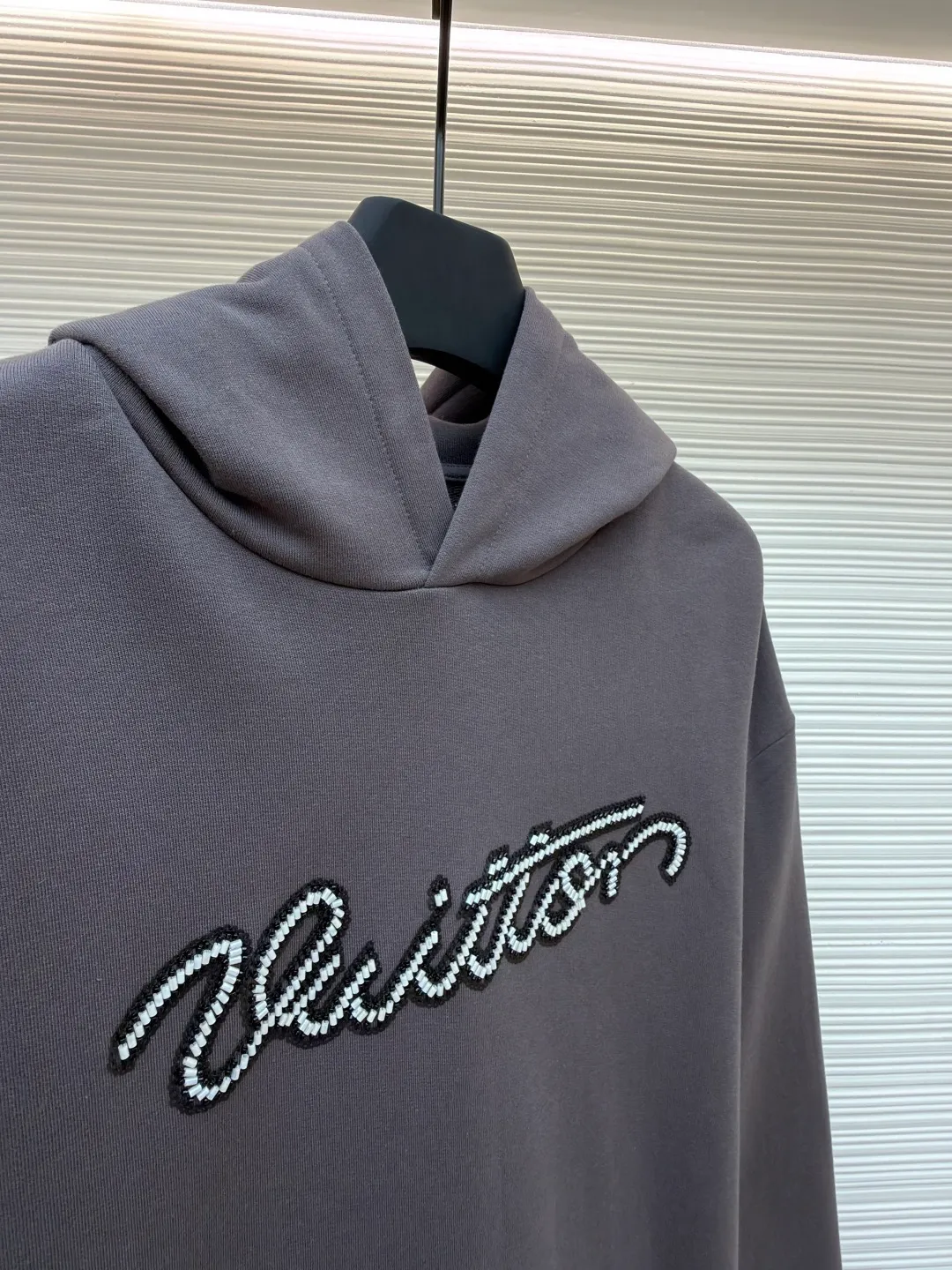 LOUIS VUITTON beaded embroidered letter hooded sweatshirt ●Original version: Purchased and developed by 13078 ●Item number: 1681742-A80 ●Fabric: pure cotton fish scale base fabric ●Technology: Pearl embroidery production ●Color: gray ●Version: fitted version ●Weight: about 805 grams ●Size: XS-S-M-L ●Description: The fabric is made of 26S double yarn + 10S fish scale bottom brushed fabric, weight 380g, with 21S double yarn 2*2 rib, weight 380g. This kind of fabric is treated with fleece to form a layer of soft and plump fluff on the inside; the improved fish scale knitting method forms a delicate concave and convex texture on the bottom surface, similar to the arrangement of fish scales. Effectively increases the air storage layer and improves thermal insulation performance. The front of the fabric is smooth and smooth, while the back is soft and waxy. It has excellent moisture absorption, breathability, wrinkle resistance and drape, and is thicker and crisper than ordinary sweatshirt materials. It gives clothes excellent warmth retention, breathability and skin-friendly touch. The Vuitton script on the chest is embroidered with beads. During the embroidery process, tiny beads are fixed on the fabric together with embroidery thread. The direct characteristics brought by this process are a strong three-dimensional sense, a unique sense of weight and a reflective effect that changes with the light. The overall wiring is straight and delicate, the fabric is comfortable and soft, and the color is consistent without color difference. It can be matched with the same style to create a fashionable look and control various occasions. Customized accessories, complete with three standards, same style for men and women!